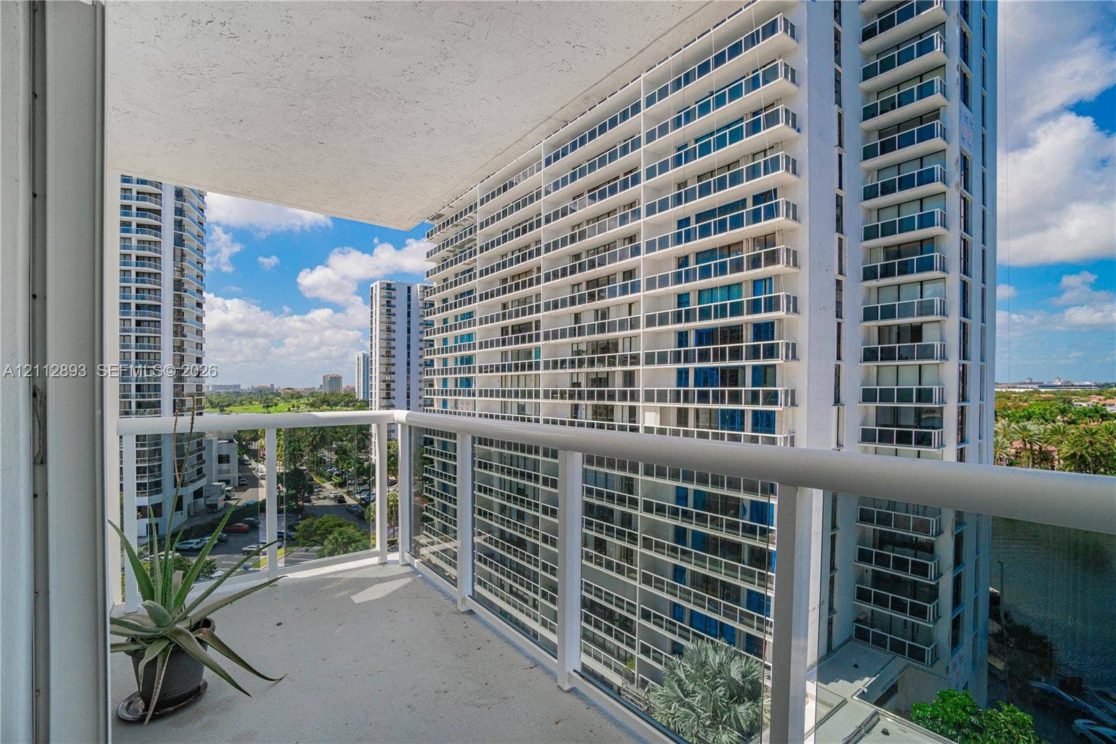 20515 E Country Club Drive, #1048, Aventura, FL 33180 Covered balcony featuring concrete flooring and a white powder-coated metal railing with glass panels