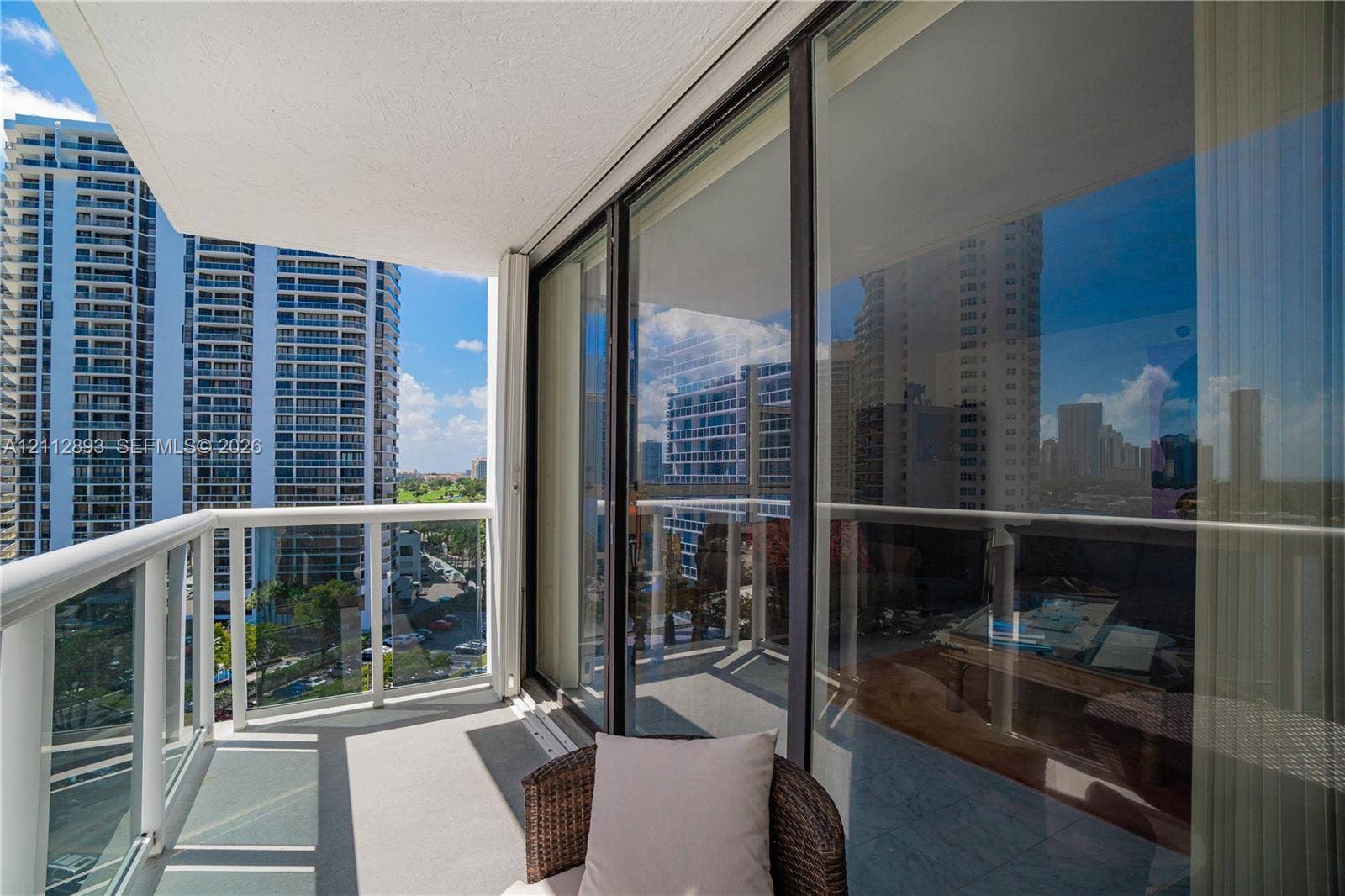 20515 E Country Club Drive, #1048, Aventura, FL 33180 Private balcony featuring a glass-panel railing, smooth concrete flooring, and full-height sliding glass doors