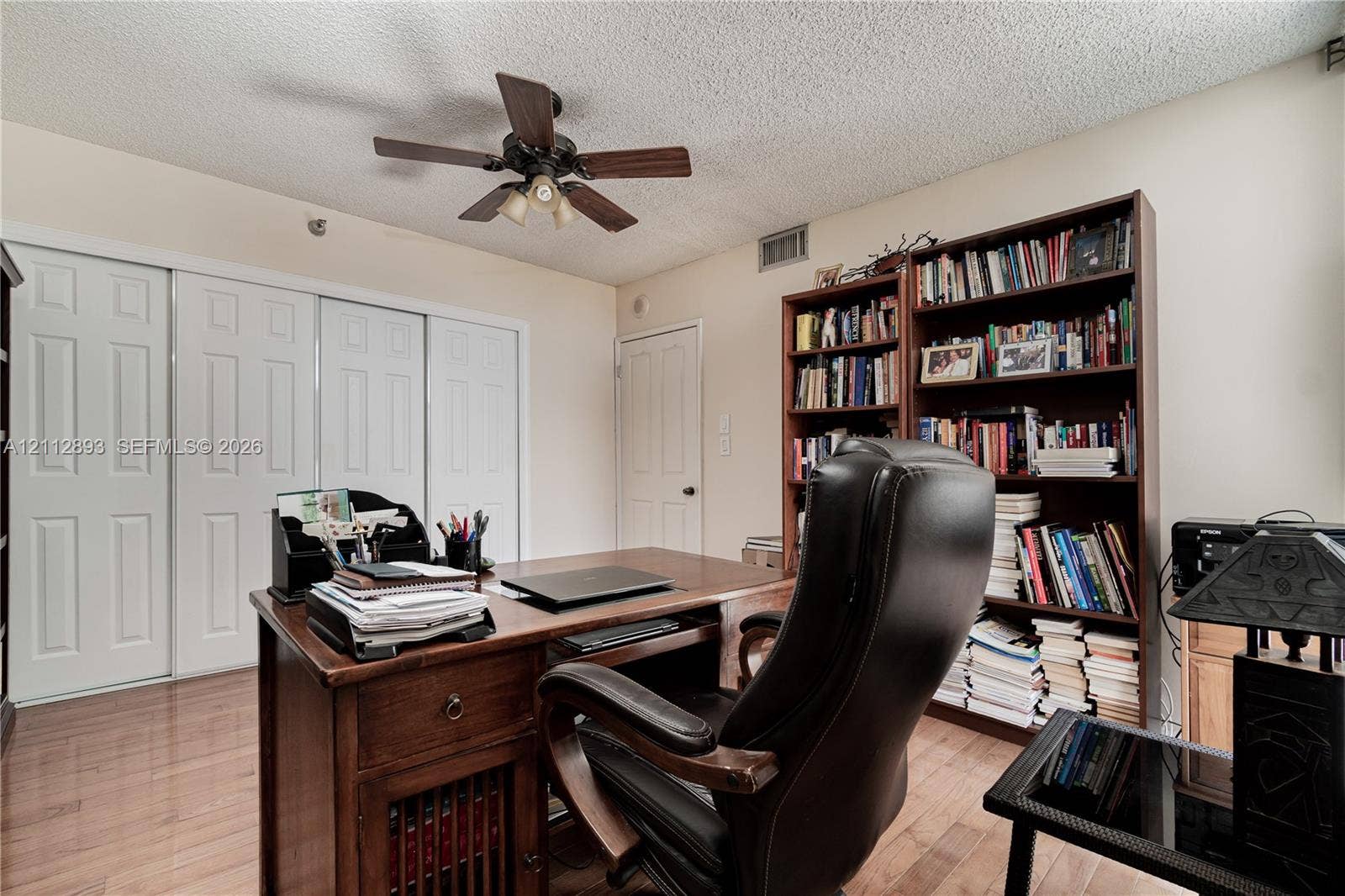 20515 E Country Club Drive, #1048, Aventura, FL 33180 Wood-finish flooring, built-in shelving, triple-panel closet doors, and ceiling fan with integrated lighting
