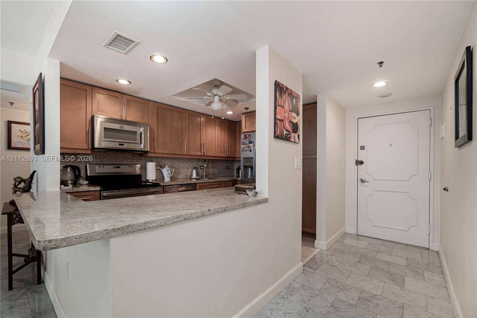 20515 E Country Club Drive, #1048, Aventura, FL 33180 Kitchen featuring light-finish cabinetry, stone countertops, stainless steel appliances, a recessed ceiling fan, and stone tile flooring