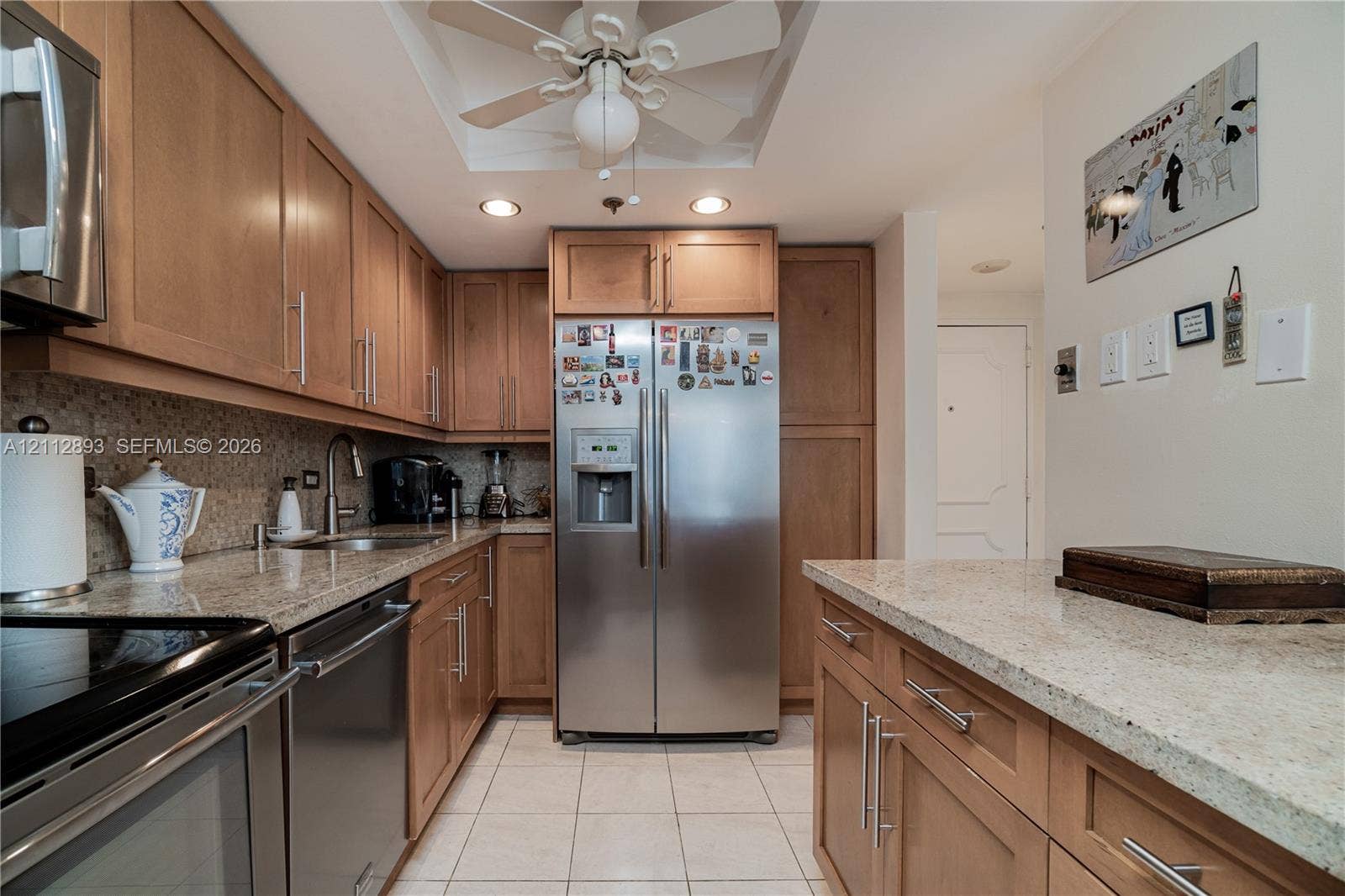 20515 E Country Club Drive, #1048, Aventura, FL 33180 Kitchen featuring natural wood cabinetry, stone-finish countertops, stainless steel appliances, tiled flooring, and recessed ceiling lighting