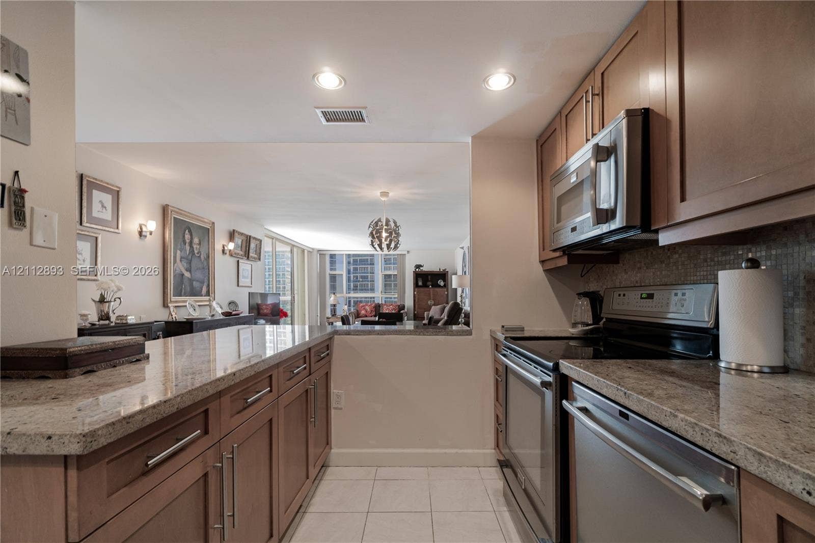 20515 E Country Club Drive, #1048, Aventura, FL 33180 Kitchen featuring stone countertops, natural wood-finish cabinetry, stainless steel appliances, and recessed lighting
