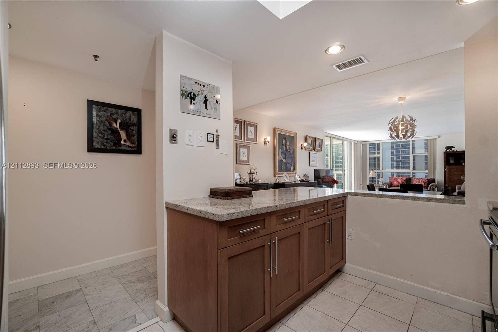 20515 E Country Club Drive, #1048, Aventura, FL 33180 Kitchen area featuring wooden cabinetry with stainless steel bar pulls, stone-composite countertops, recessed lighting, and tile flooring