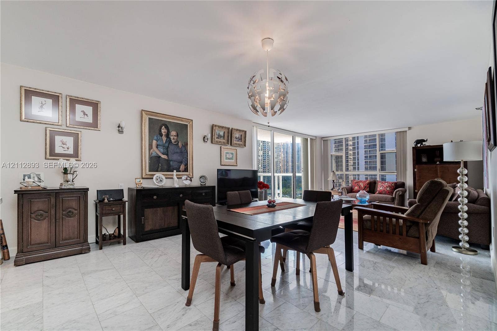 20515 E Country Club Drive, #1048, Aventura, FL 33180 Open-concept living space featuring polished stone flooring, floor-to-ceiling glass sliding doors, and a modern spherical pendant light fixture