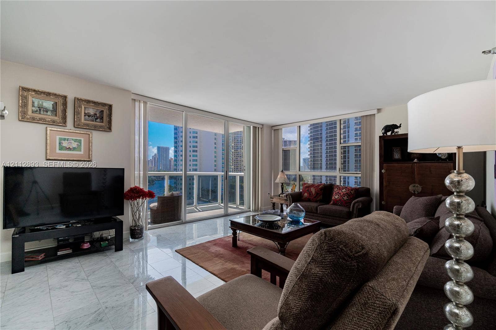 20515 E Country Club Drive, #1048, Aventura, FL 33180 Polished stone flooring, expansive glass sliding doors, and floor-to-ceiling windows