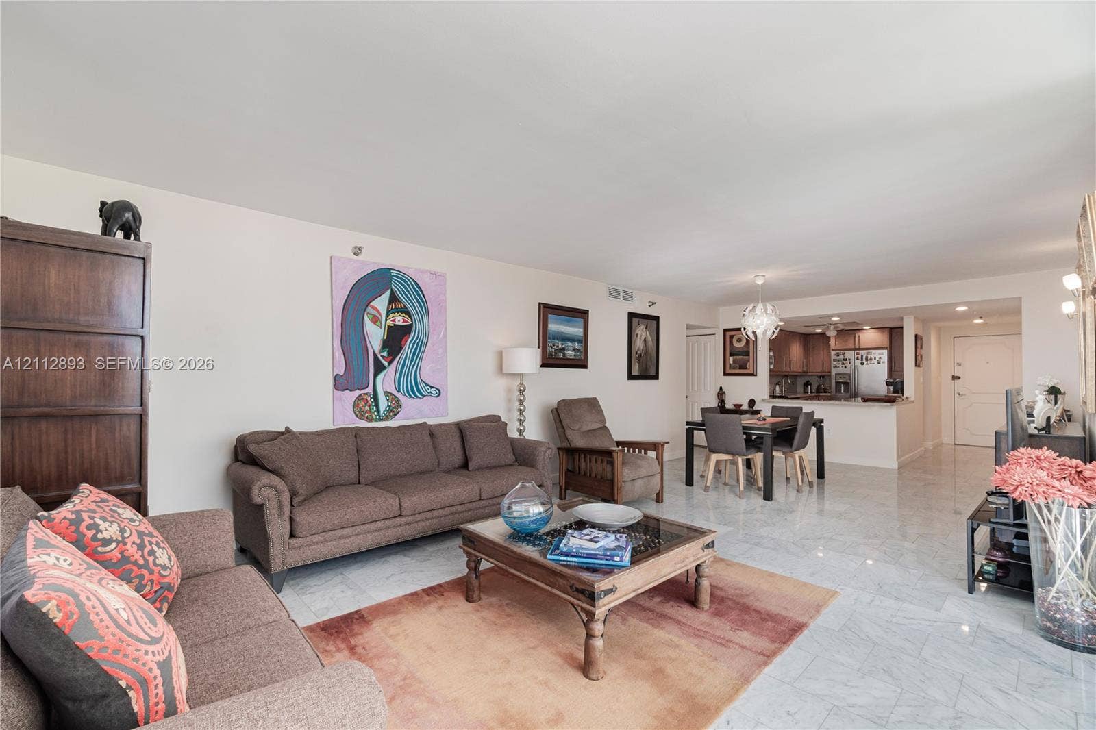 20515 E Country Club Drive, #1048, Aventura, FL 33180 Open-concept interior featuring light-toned stone tile flooring, crown molding, and a multi-arm chandelier