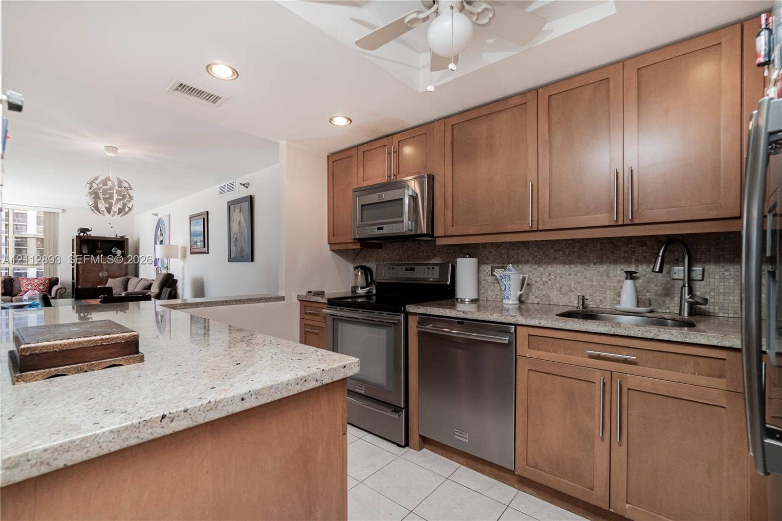20515 E Country Club Drive, #1048, Aventura, FL 33180 Kitchen featuring wood cabinetry, stone countertops, stainless steel appliances, tiled backsplash, and recessed lighting