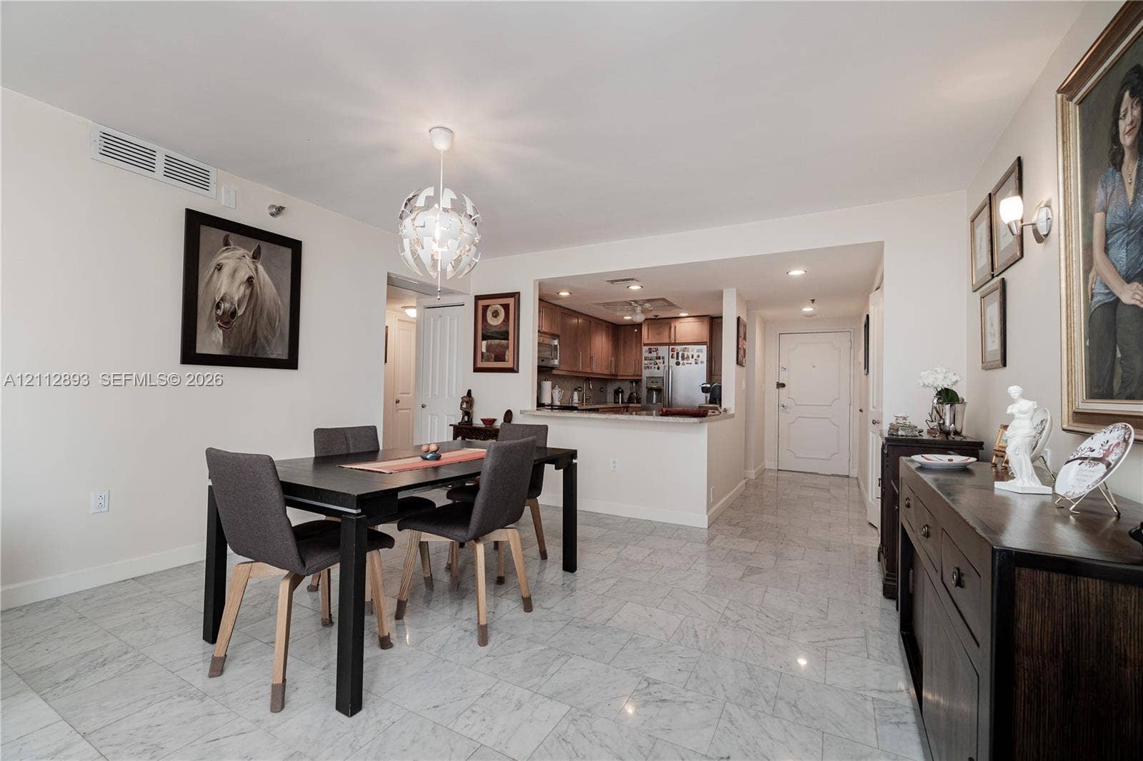 20515 E Country Club Drive, #1048, Aventura, FL 33180 Stone tile flooring, decorative multi-faceted globe pendant lighting, recessed ceiling lighting, and pass-through opening with countertop
