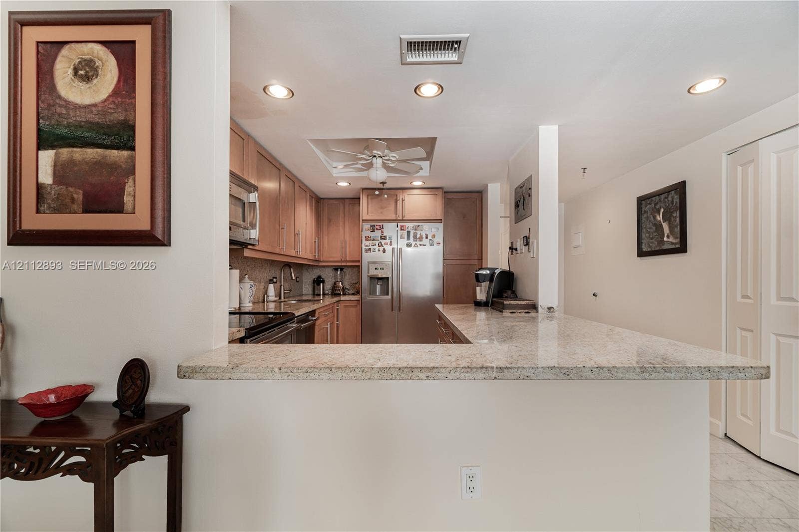 20515 E Country Club Drive, #1048, Aventura, FL 33180 Kitchen featuring stone-finish countertops, stainless steel appliances, light wood cabinetry, recessed lighting, and a breakfast bar