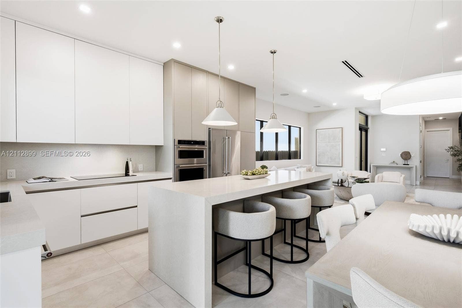 2747 SW 23rd Terrace, Miami, FL 33145 Kitchen featuring floor-to-ceiling cabinetry, a waterfall-edge center island, stone countertops, recessed lighting, and stainless steel built-in double wall ovens