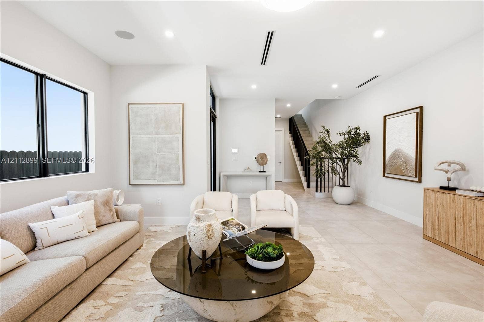2747 SW 23rd Terrace, Miami, FL 33145 Open-concept interior featuring large-format tile flooring, recessed lighting, and a staircase with a black metal railing