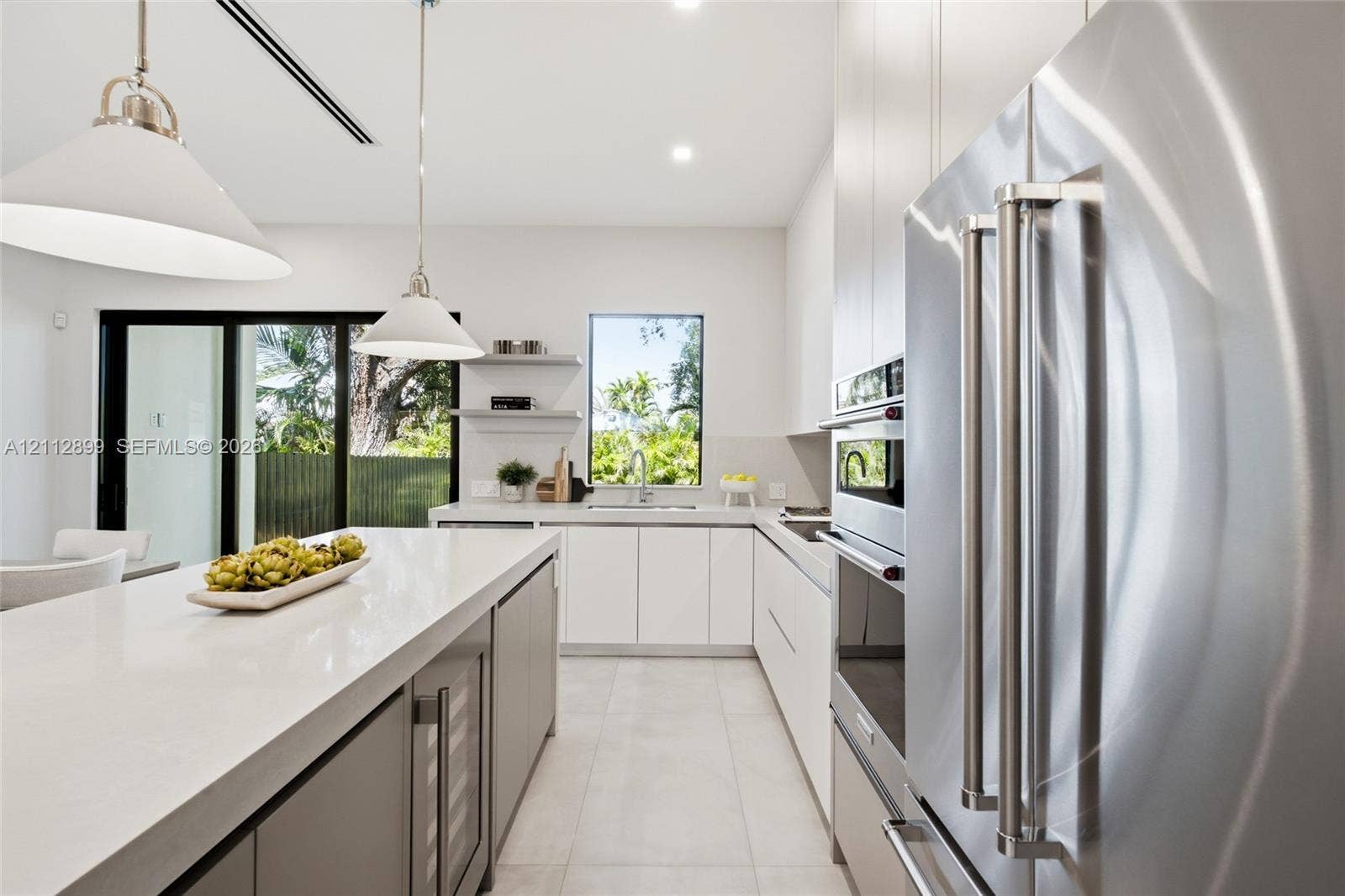 2747 SW 23rd Terrace, Miami, FL 33145 Kitchen featuring quartz countertops, flat-panel cabinetry, stainless steel built-in appliances, a wine refrigerator, and pendant lighting