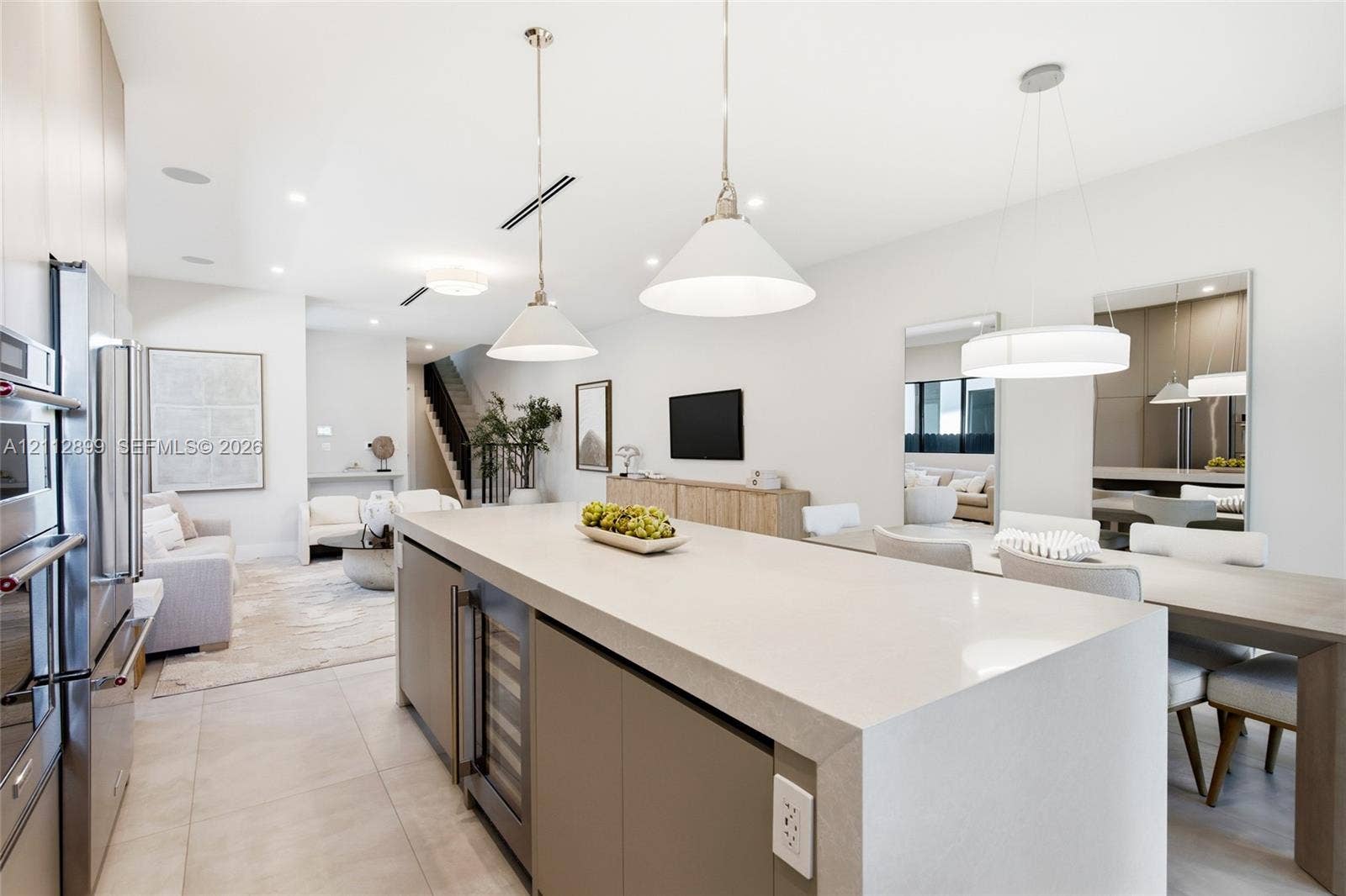 2747 SW 23rd Terrace, Miami, FL 33145 Large kitchen island with quartz waterfall countertop, integrated wine refrigerator, recessed lighting, matte-finish cabinetry, and oversized pendant fixtures