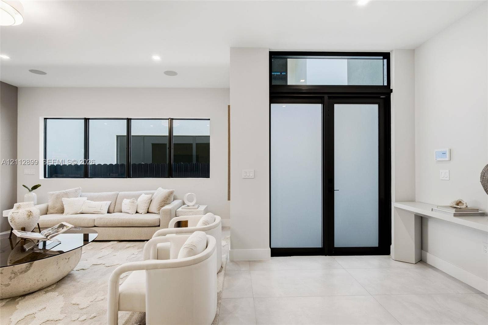 2747 SW 23rd Terrace, Miami, FL 33145 Double entry doors with frosted glass panels and an overhead transom window, large-format tile flooring, recessed lighting, and a built-in wall-mounted console