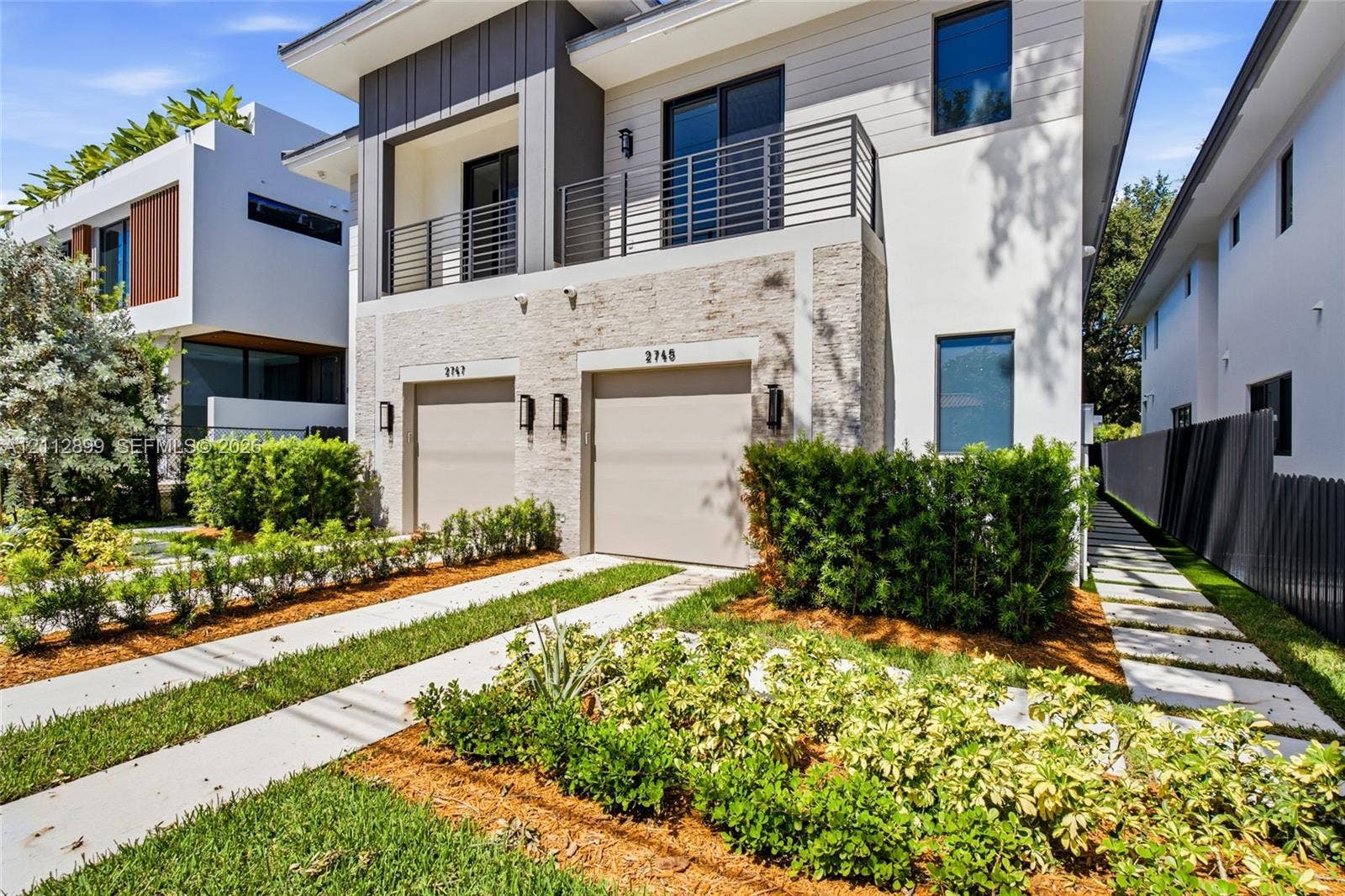 2747 SW 23rd Terrace, Miami, FL 33145 Modern two-story architectural exterior featuring smooth stucco, horizontal lap siding, and natural stone veneer accents