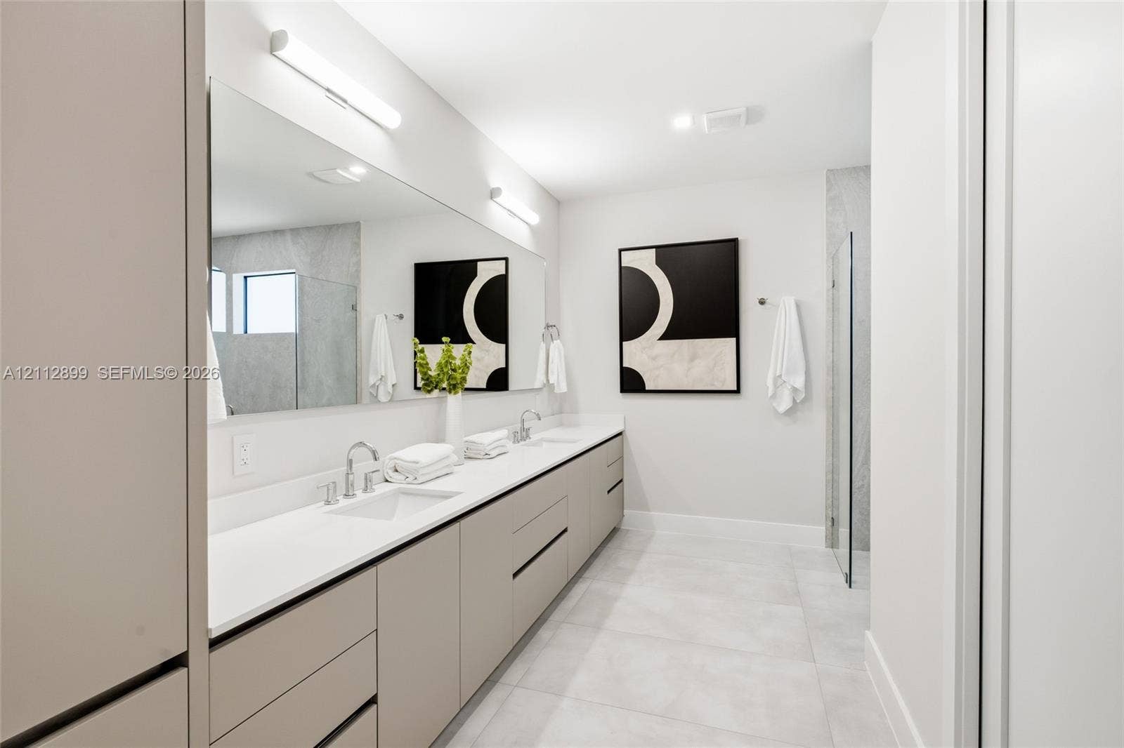 2747 SW 23rd Terrace, Miami, FL 33145 Extended floating vanity with dual undermount sinks, quartz countertop, full-width mirror, and walk-in shower with glass enclosure