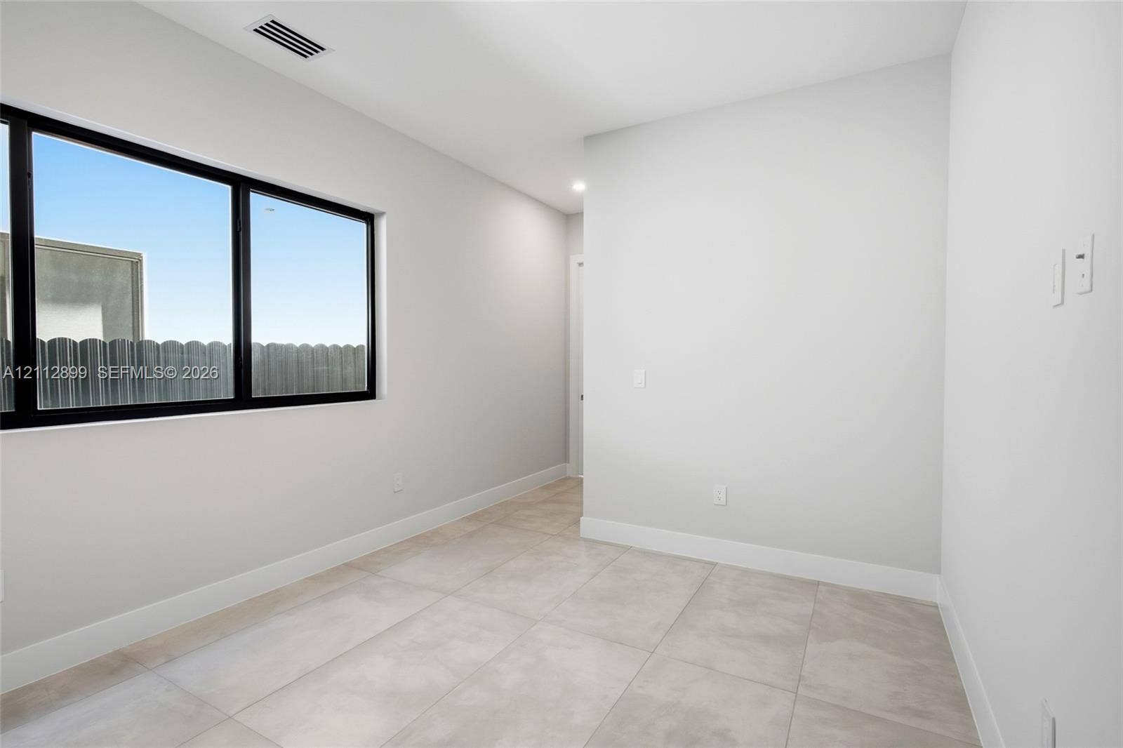 2747 SW 23rd Terrace, Miami, FL 33145 Neutral-toned tile flooring, oversized window with black frame, and smooth-finish walls