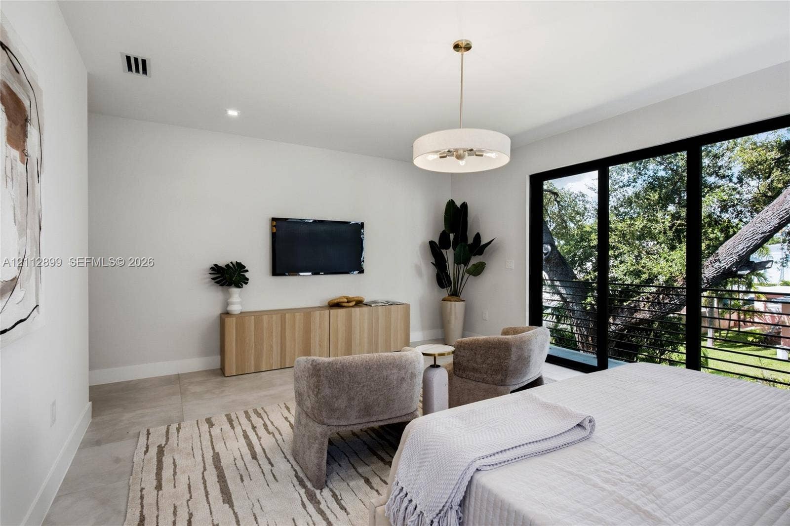 2747 SW 23rd Terrace, Miami, FL 33145 Large-format tile flooring, drum-style chandelier with metallic accents, built-in light-tone wood-finish cabinetry, and floor-to-ceiling sliding glass doors with metal railings