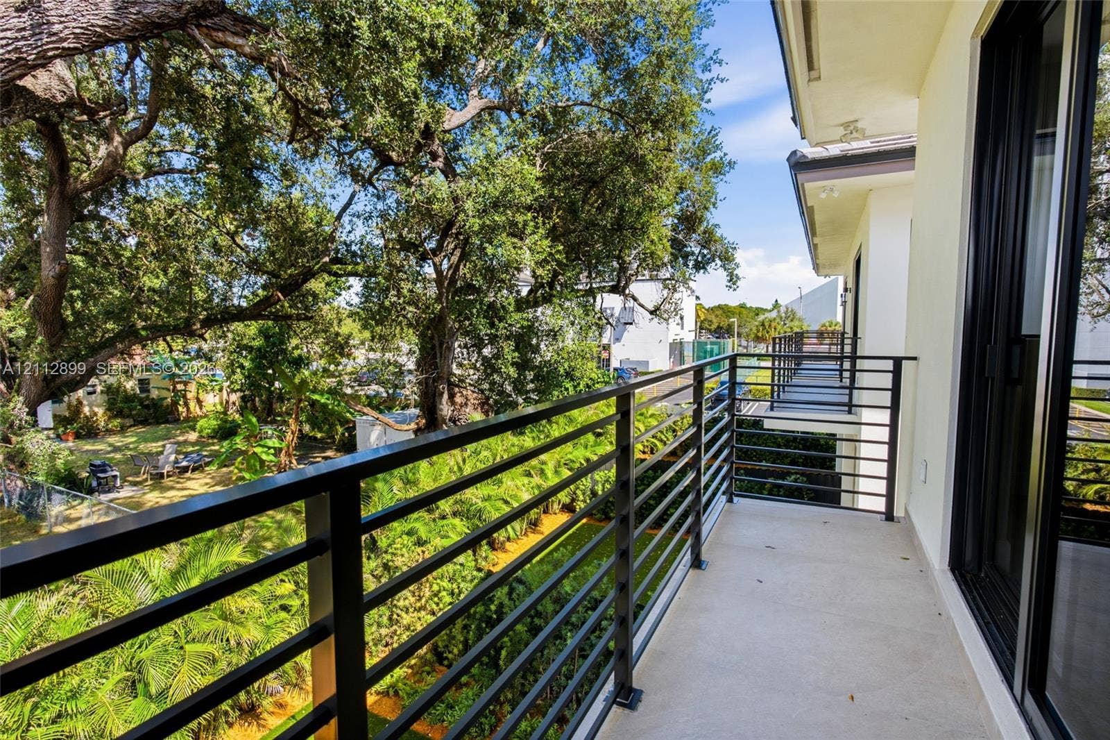 2747 SW 23rd Terrace, Miami, FL 33145 Covered balcony featuring concrete flooring and a black horizontal metal railing