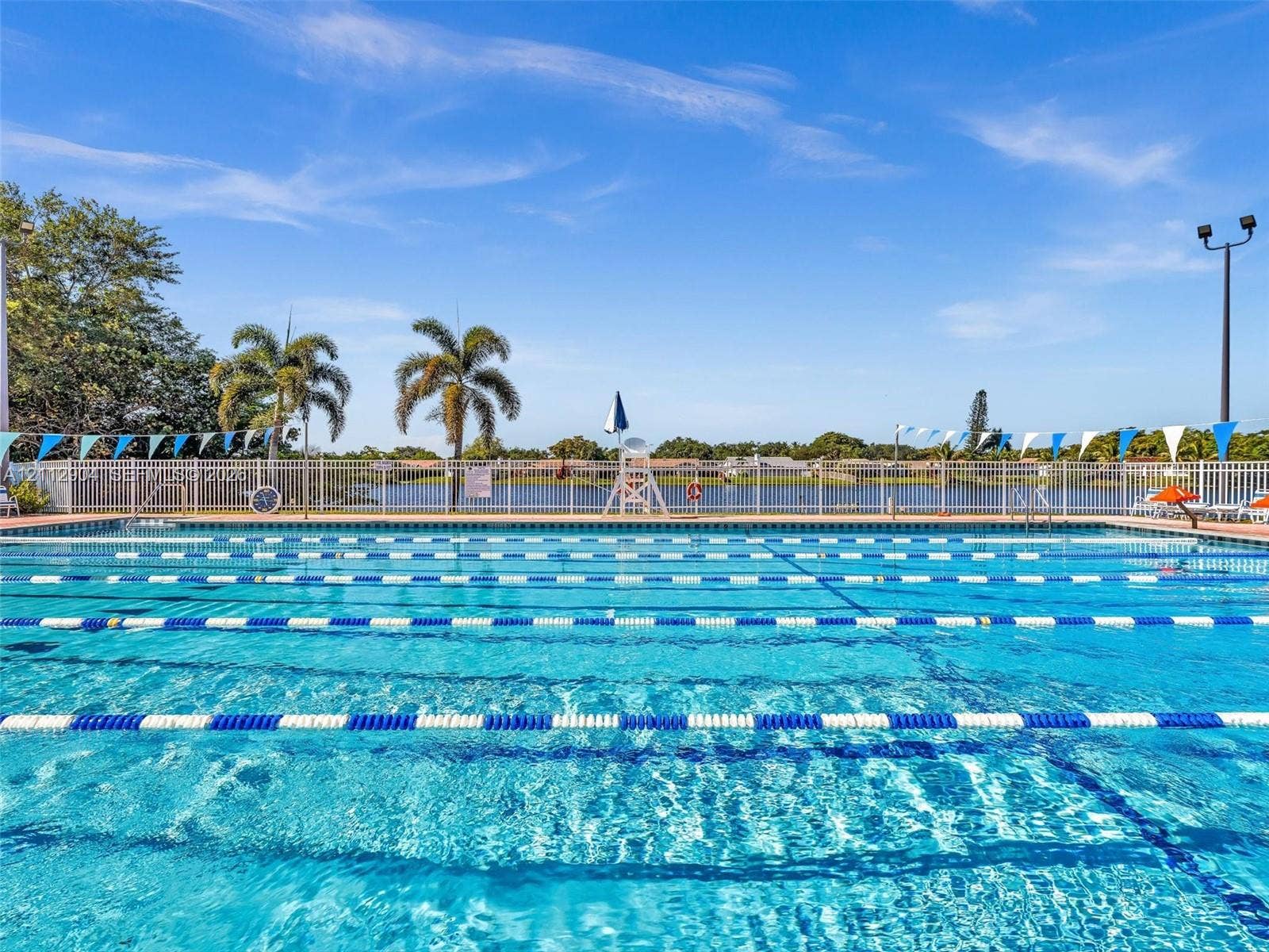 76 Forest Circle, Cooper City, FL 33026 Lap swimming pool featuring marked lanes, surrounding perimeter fencing, and water frontage