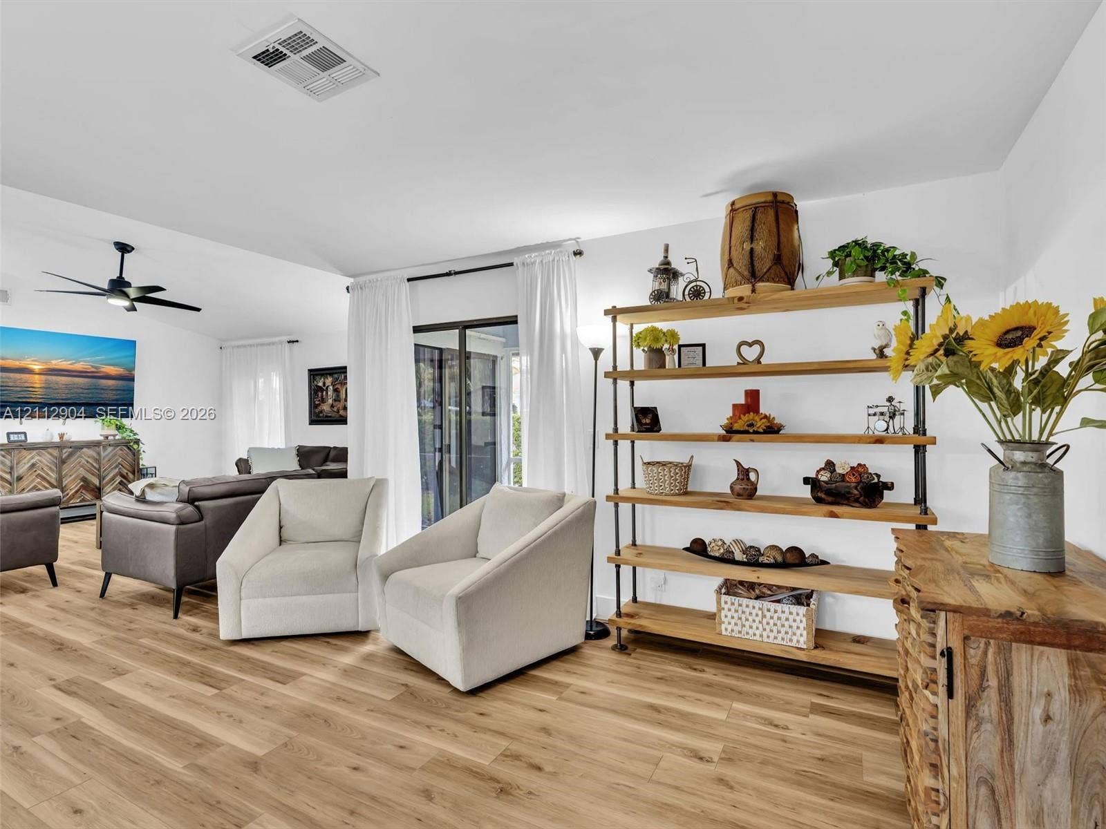 76 Forest Circle, Cooper City, FL 33026 Open-concept interior featuring wood-finish flooring, vaulted ceilings, a ceiling fan, and sliding glass doors