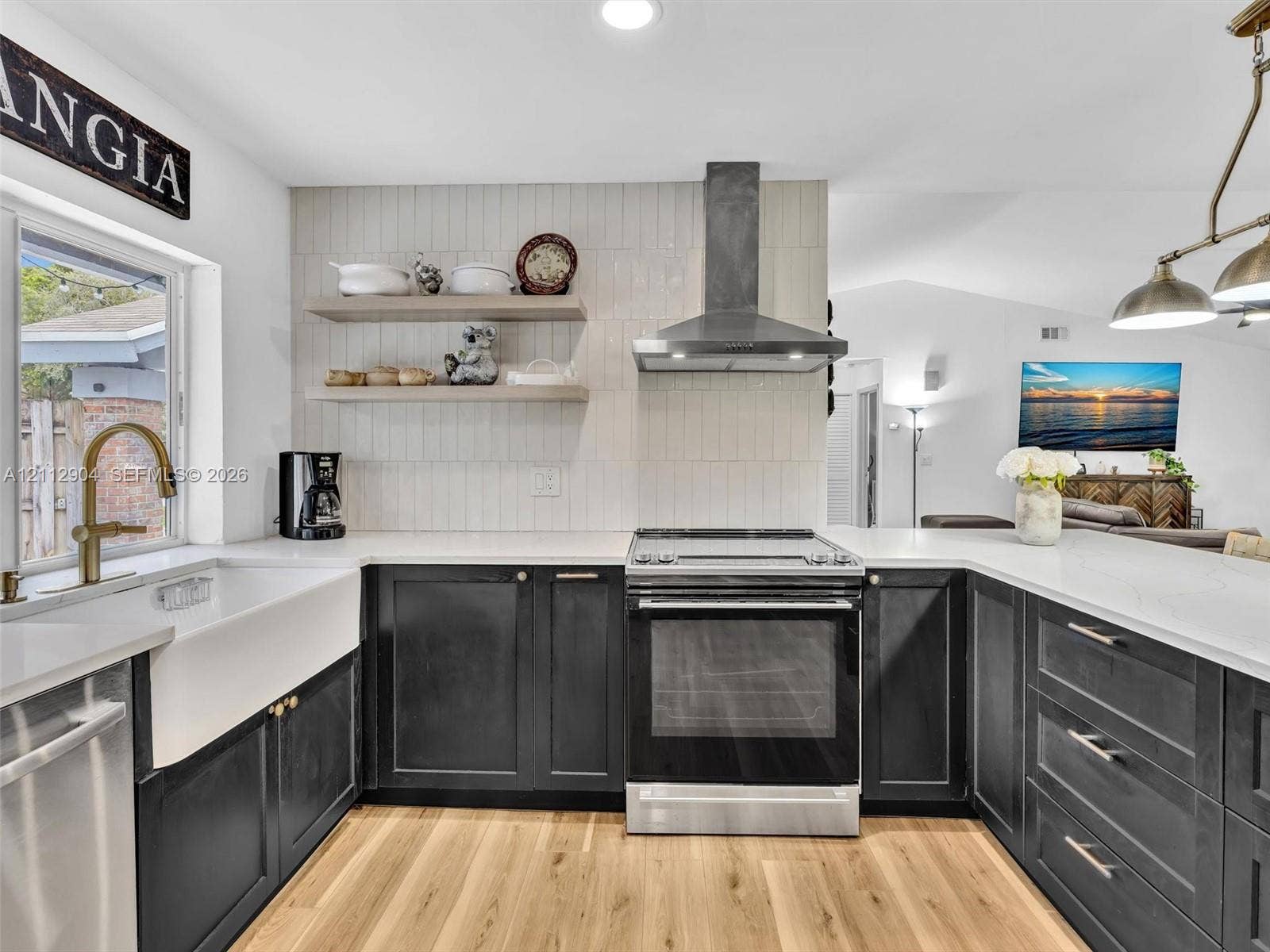 76 Forest Circle, Cooper City, FL 33026 Kitchen featuring dark-finish cabinetry, white countertops, a deep apron-front sink, vertical-set wall tile backsplash, and wood-finish flooring