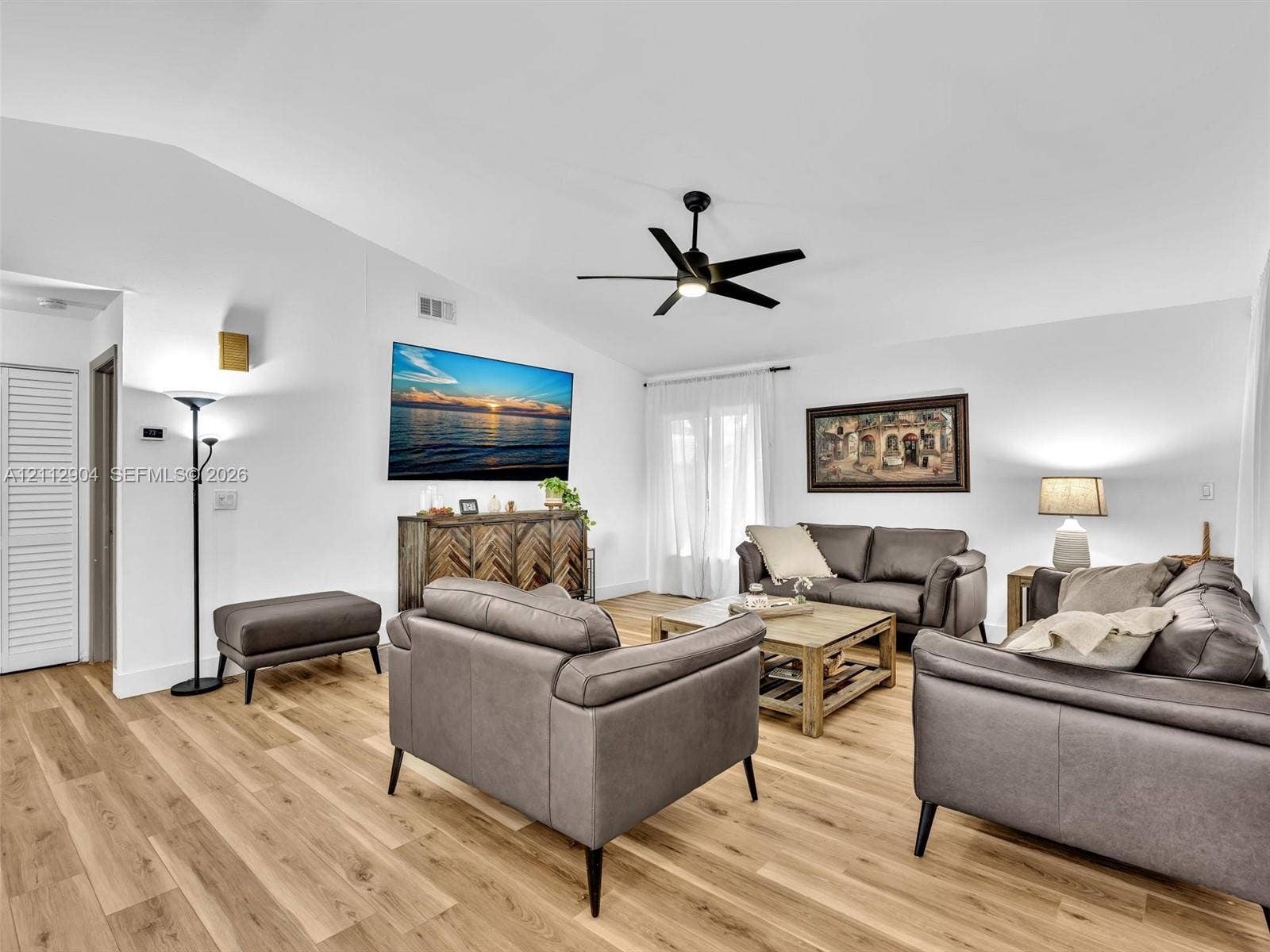 76 Forest Circle, Cooper City, FL 33026 Living area featuring vaulted ceilings, wood-finish flooring, and a central ceiling fan with an integrated light fixture