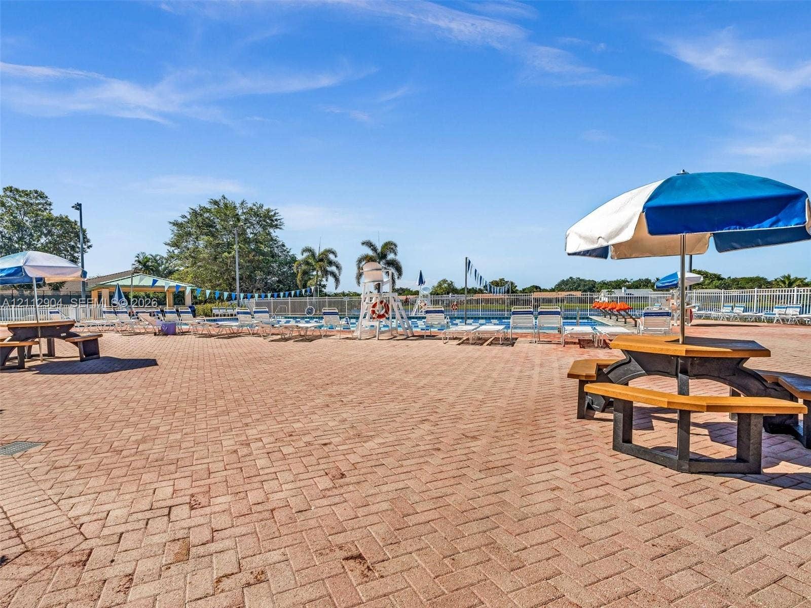 76 Forest Circle, Cooper City, FL 33026 Swimming pool area with expansive paver deck, permanent picnic structures, and perimeter fencing