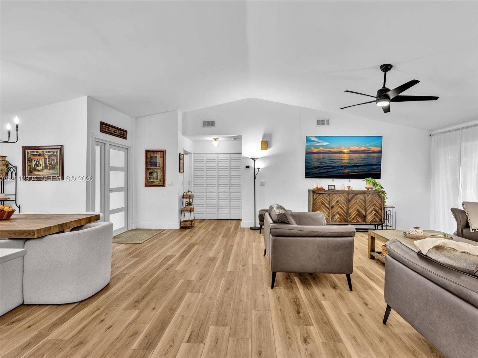 76 Forest Circle, Cooper City, FL 33026 Vaulted ceilings, wood-finish flooring, matte black ceiling fan, multi-pane glass entry door, and folding louvered closet doors