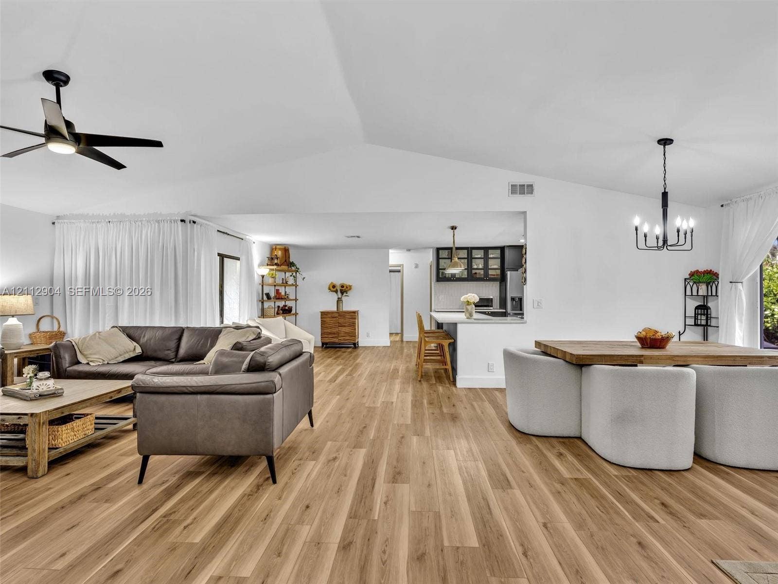 76 Forest Circle, Cooper City, FL 33026 Vaulted ceilings, wood-finish flooring, recessed lighting, matte black ceiling fan, and a multi-arm chandelier