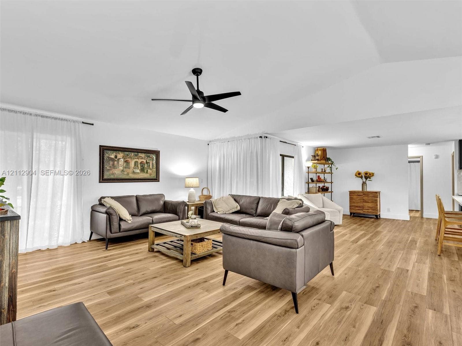 76 Forest Circle, Cooper City, FL 33026 Living area featuring wood-finish flooring, vaulted ceilings, and a central matte black ceiling fan