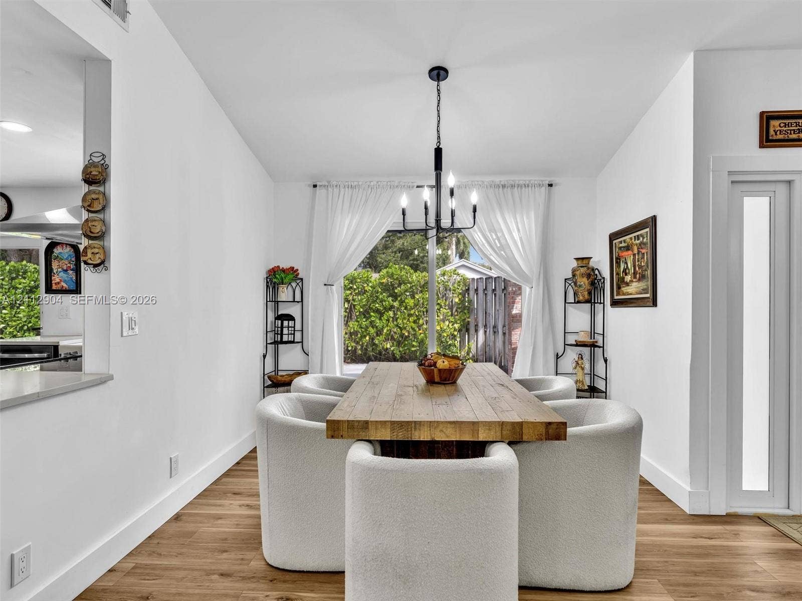 76 Forest Circle, Cooper City, FL 33026 Dining area featuring wood-finish flooring, a contemporary six-arm chandelier, and sliding glass doors with direct exterior access