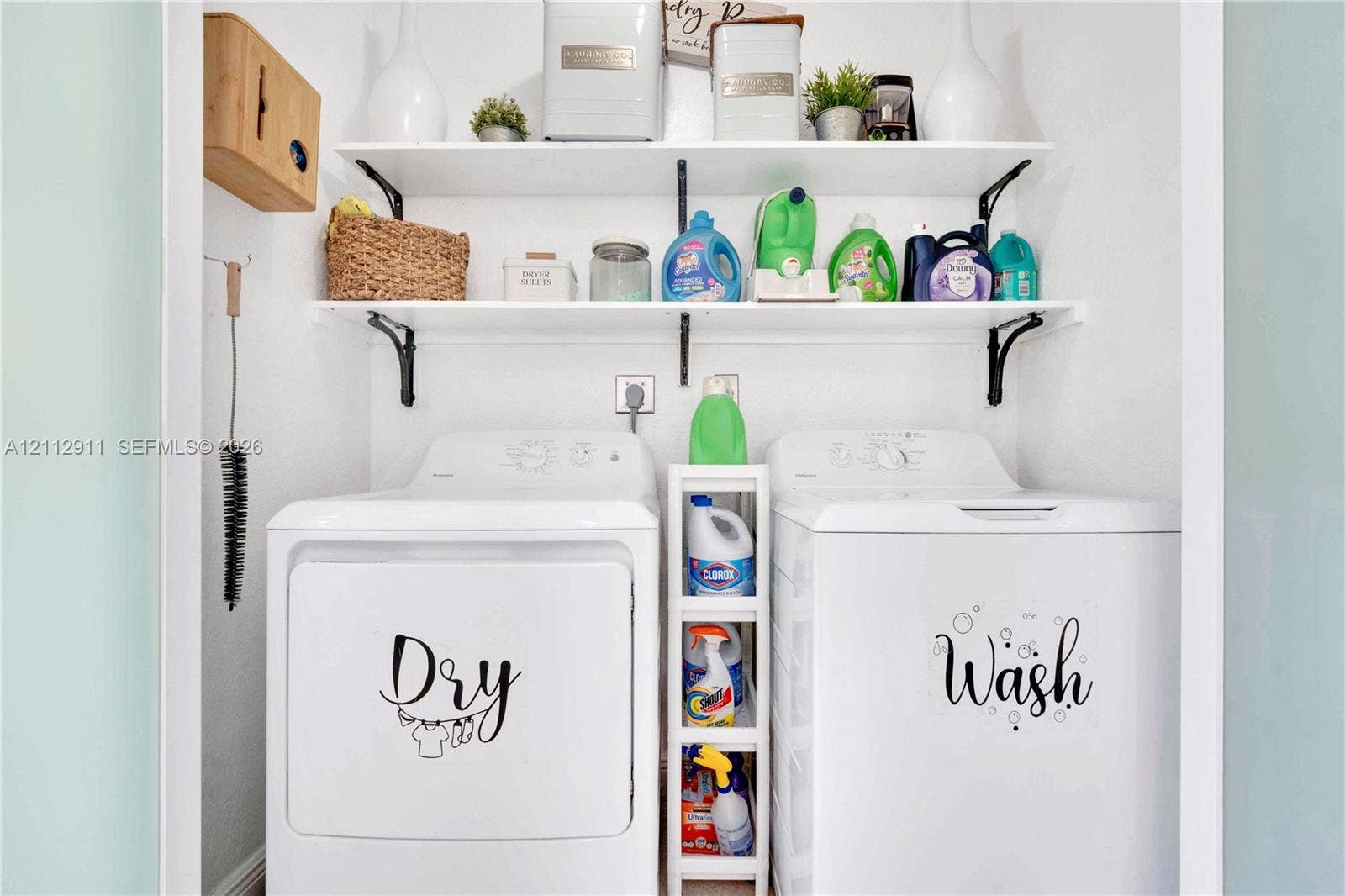 217 SW 15th Place, Homestead, FL 33030 Laundry nook featuring dual-level white wall-mounted shelving with black metal support brackets