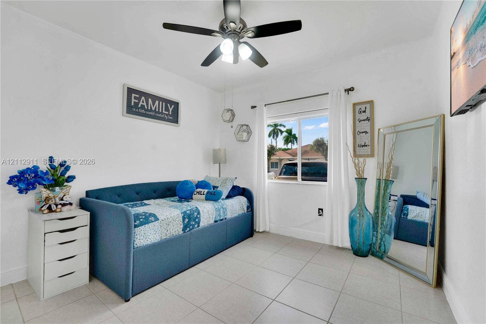 217 SW 15th Place, Homestead, FL 33030 Neutral-toned tile flooring, multi-blade ceiling fan with integrated light fixture, and single-pane sliding window