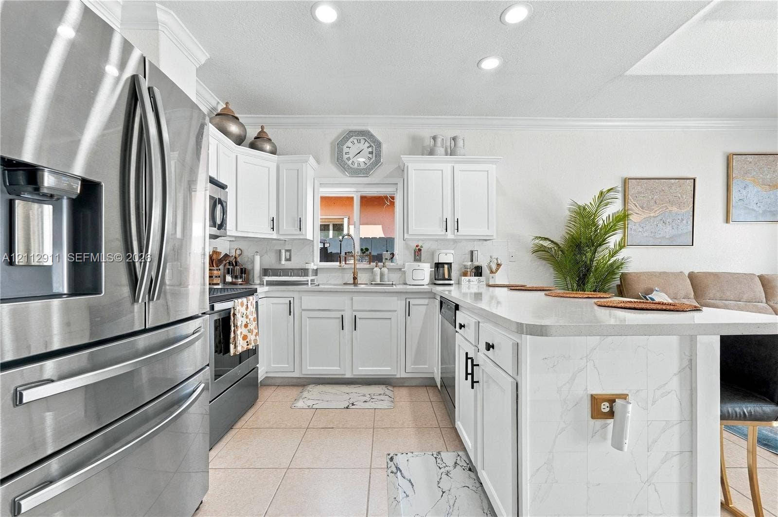 217 SW 15th Place, Homestead, FL 33030 Kitchen featuring white cabinetry, stainless steel appliances, and a central island with a stone-finish countertop
