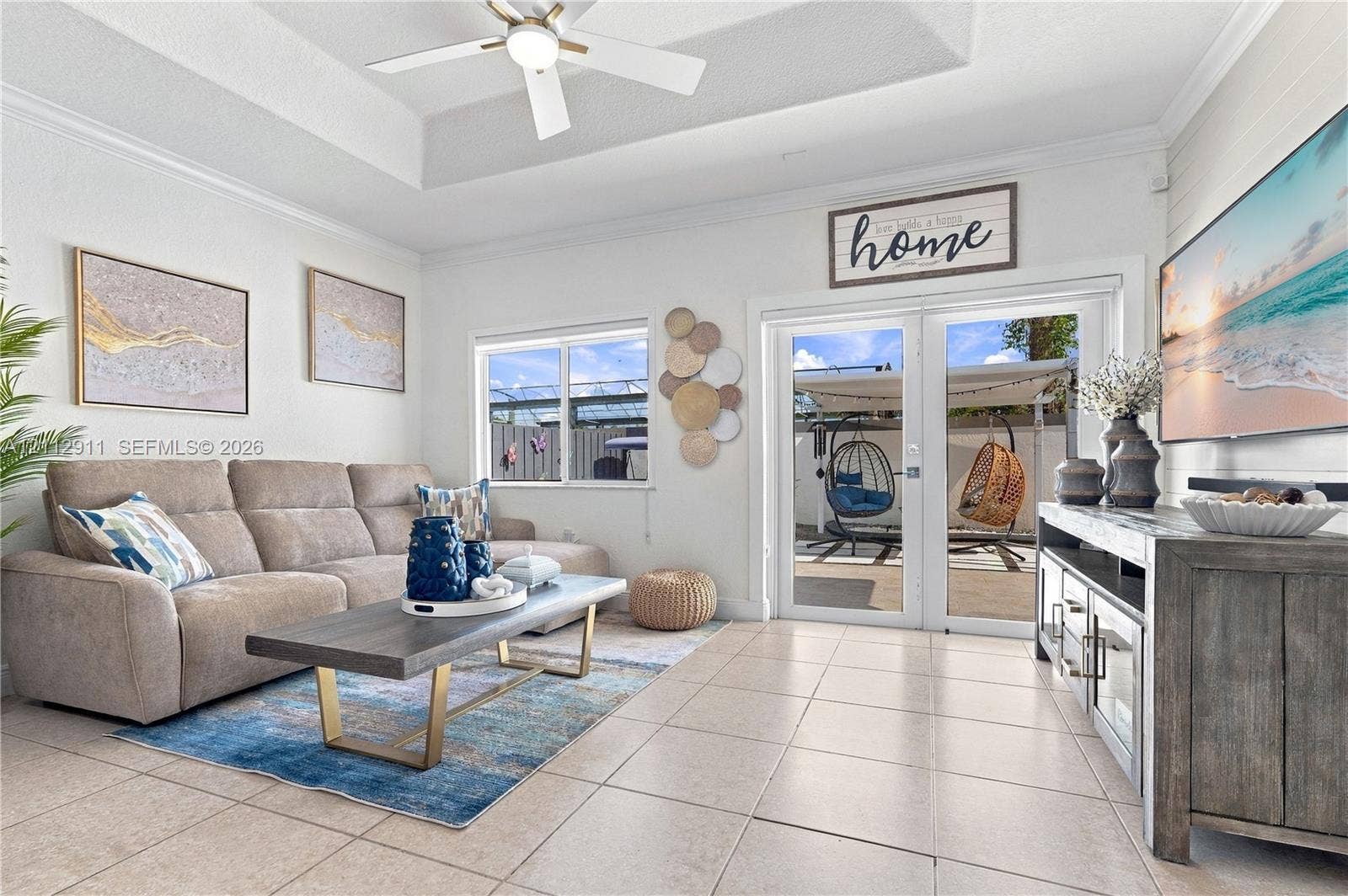 217 SW 15th Place, Homestead, FL 33030 Living area featuring a tray ceiling, ceiling fan, neutral ceramic tile flooring, and glass-paned double doors