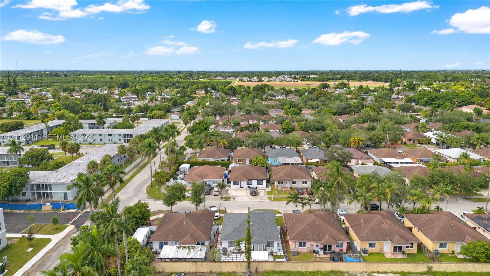 217 SW 15th Place, Homestead, FL 33030 Aerial perspective of a residential neighborhood featuring paved streets, mature palm trees, and diverse single-story architectural styles
