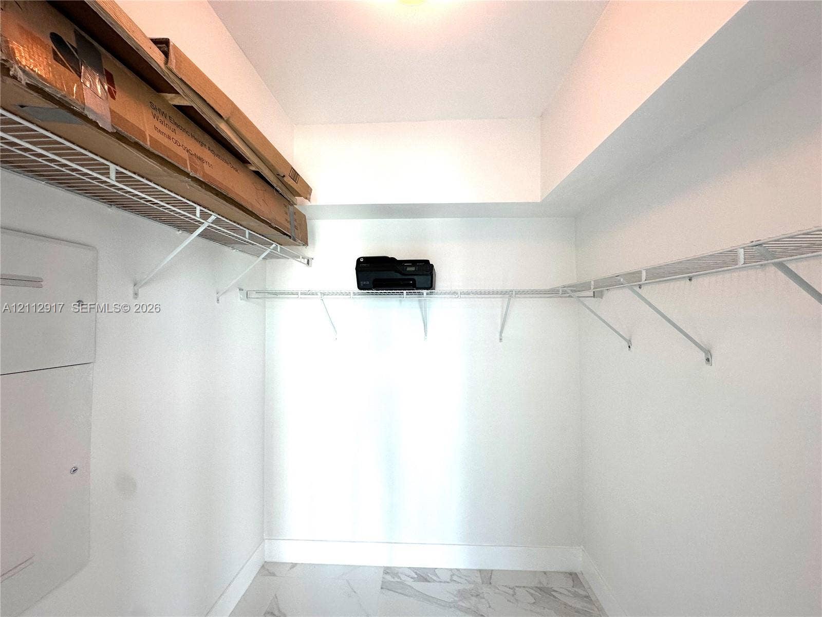 951 Brickell Avenue, #2601, Miami, Miami, FL 33131 Walk-in closet featuring white walls, stone-finish flooring, and tiered wire shelving