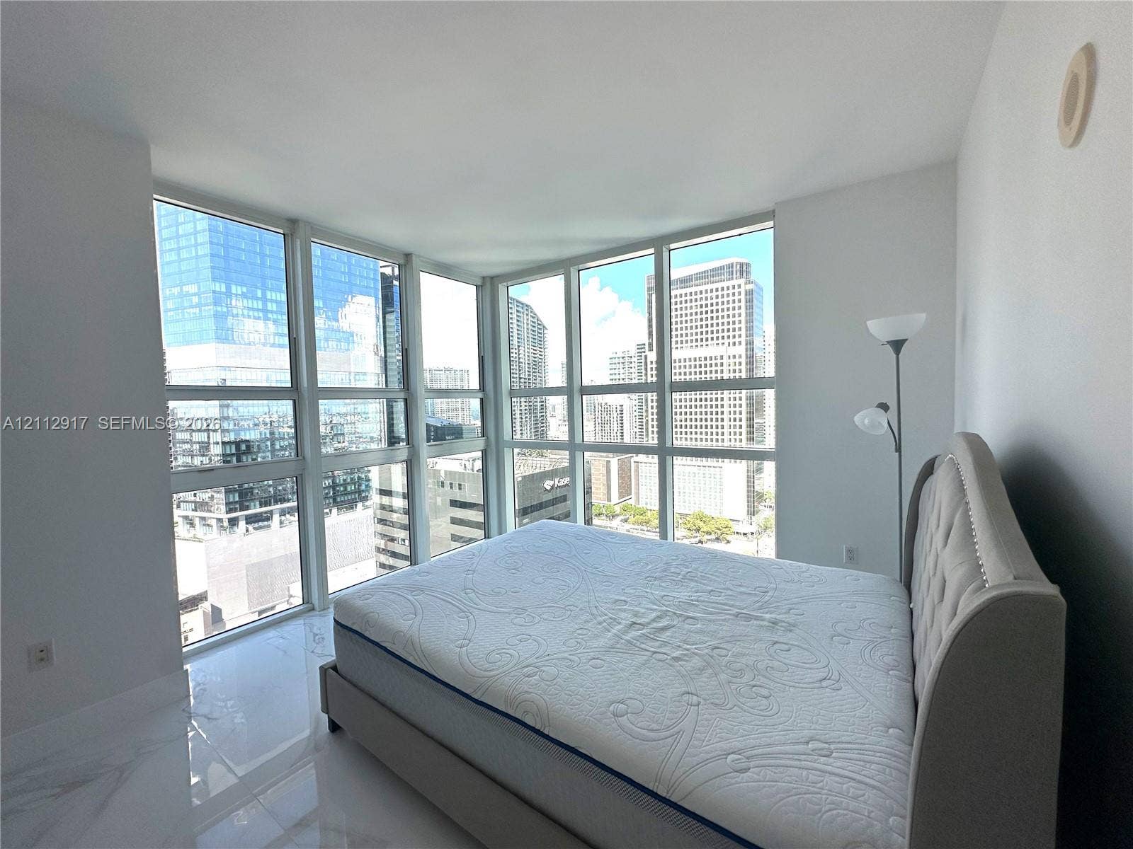 951 Brickell Avenue, #2601, Miami, Miami, FL 33131 Interior featuring polished stone-finish flooring, white walls, and floor-to-ceiling multi-pane windows showcasing urban architecture