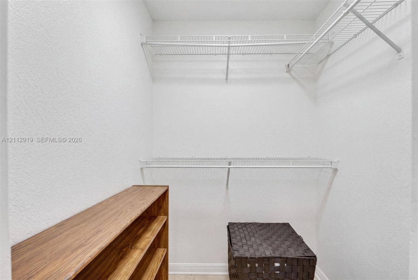 2120 NW 28th Terrace, Fort Lauderdale, FL 33311 Walk-in storage space featuring dual-tier coated wire shelving and a built-in wood-finish shelving unit