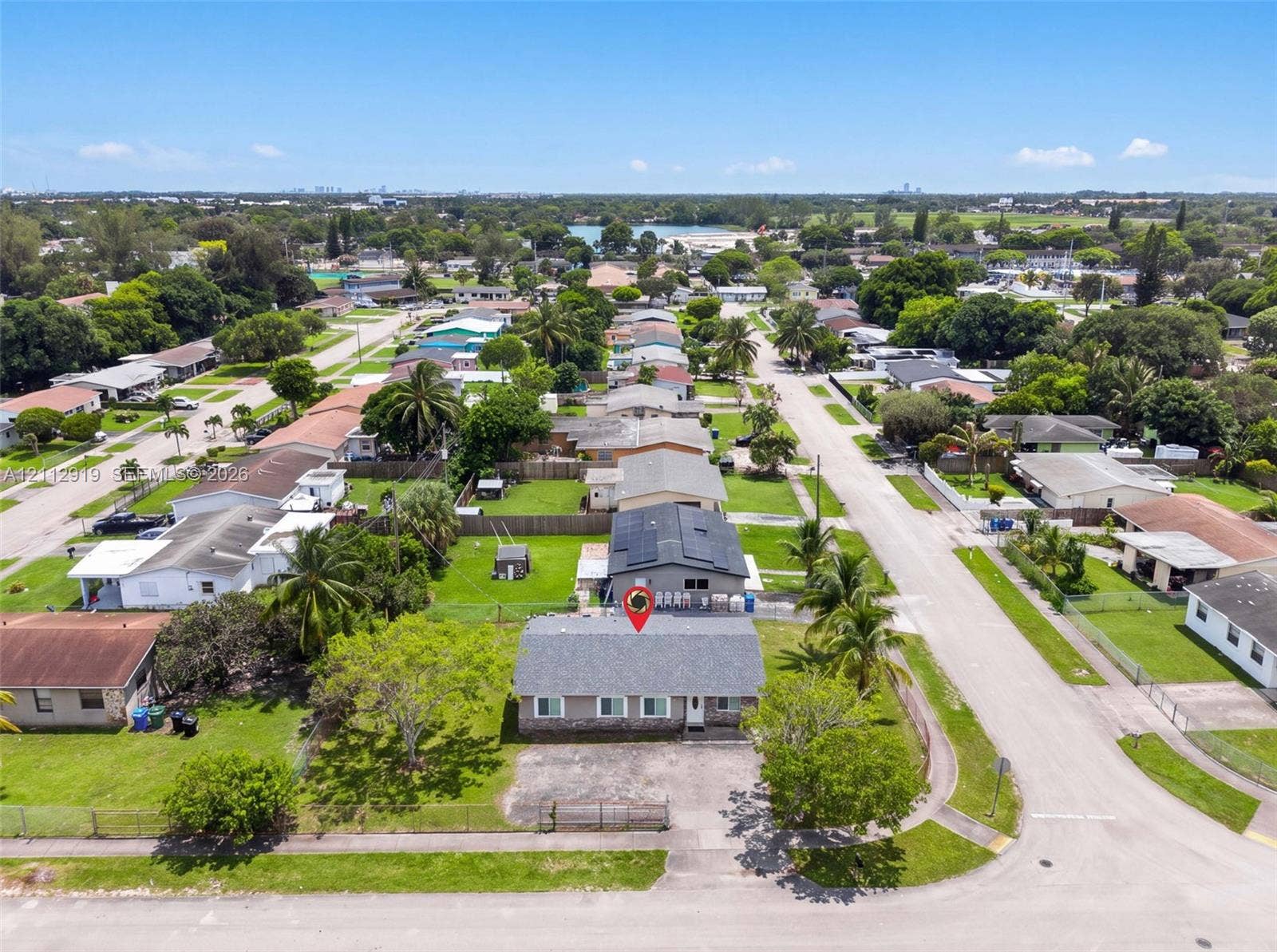 2120 NW 28th Terrace, Fort Lauderdale, FL 33311 Single-story residence featuring a shingle roof, stone-veneer accent siding, and a paved front driveway