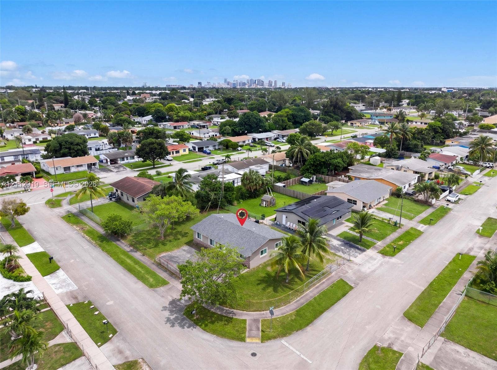 2120 NW 28th Terrace, Fort Lauderdale, FL 33311 Corner lot property featuring a low-slope roof, concrete driveway, and mature landscaping
