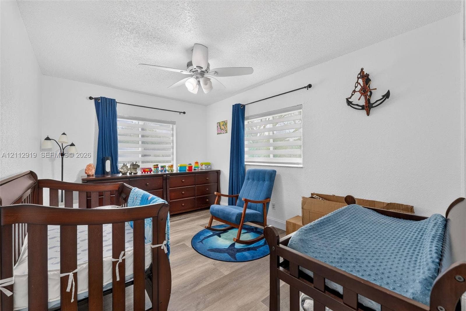 2120 NW 28th Terrace, Fort Lauderdale, FL 33311 Wood-finish flooring, dual windows with fitted shades, and a ceiling-mounted light fixture with a fan