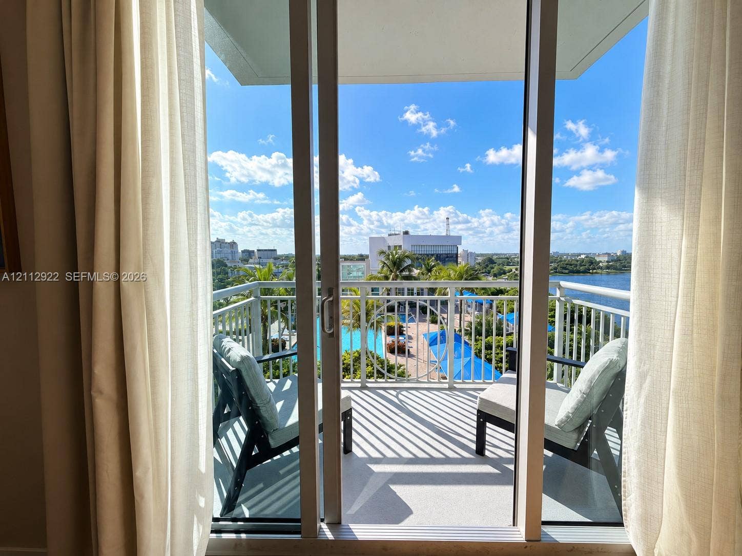 Private balcony featuring metal railings and concrete flooring, accessible via sliding glass doors