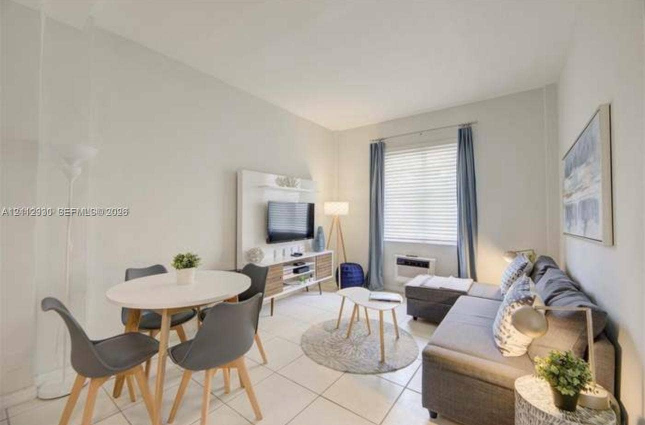 3030 Collins Avenue, #1G, Miami Beach, FL 33140 Neutral-toned interior featuring large-format tile flooring and a built-in media console