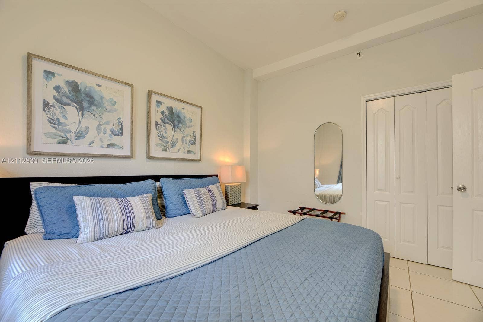 3030 Collins Avenue, #1G, Miami Beach, FL 33140 Neutral-toned walls, tile flooring, and a multi-panel closet door