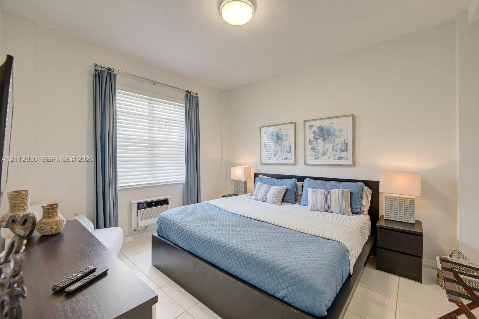 3030 Collins Avenue, #1G, Miami Beach, FL 33140 Neutral-toned room featuring large-format tile flooring, a recessed ceiling light fixture, and a wall-mounted window air conditioning unit