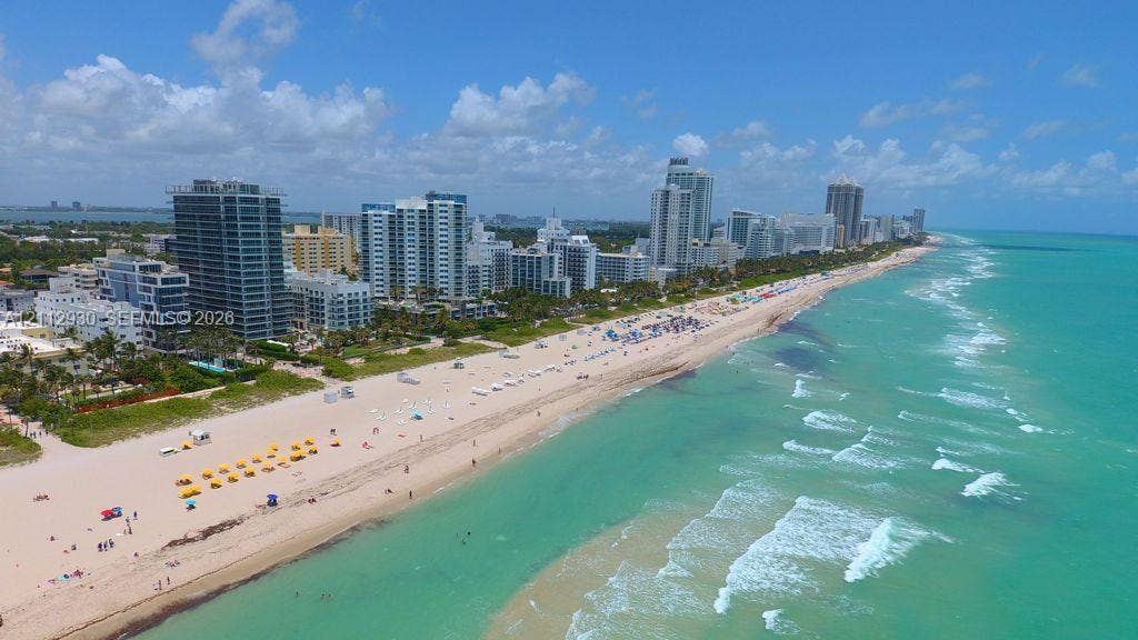 3030 Collins Avenue, #1G, Miami Beach, FL 33140 Coastal aerial perspective featuring direct oceanfront access, sandy shoreline, and high-rise structures