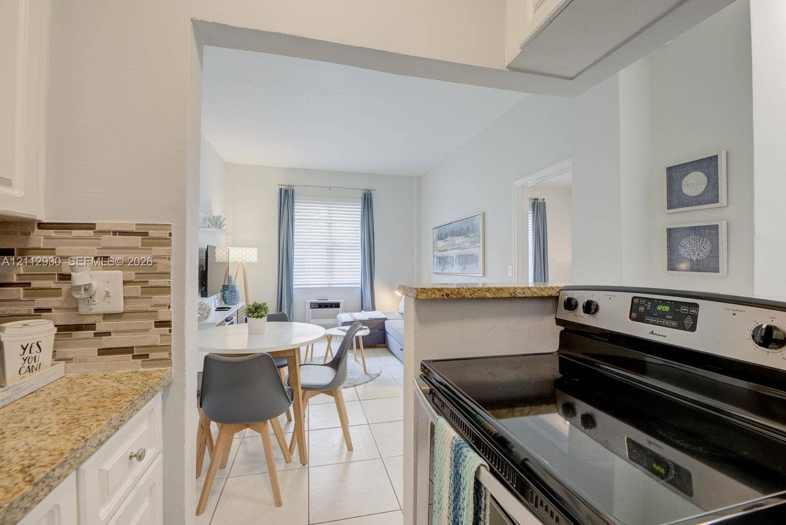 3030 Collins Avenue, #1G, Miami Beach, FL 33140 Kitchen featuring stone-finish countertops, tile flooring, and a multi-toned glass tile backsplash