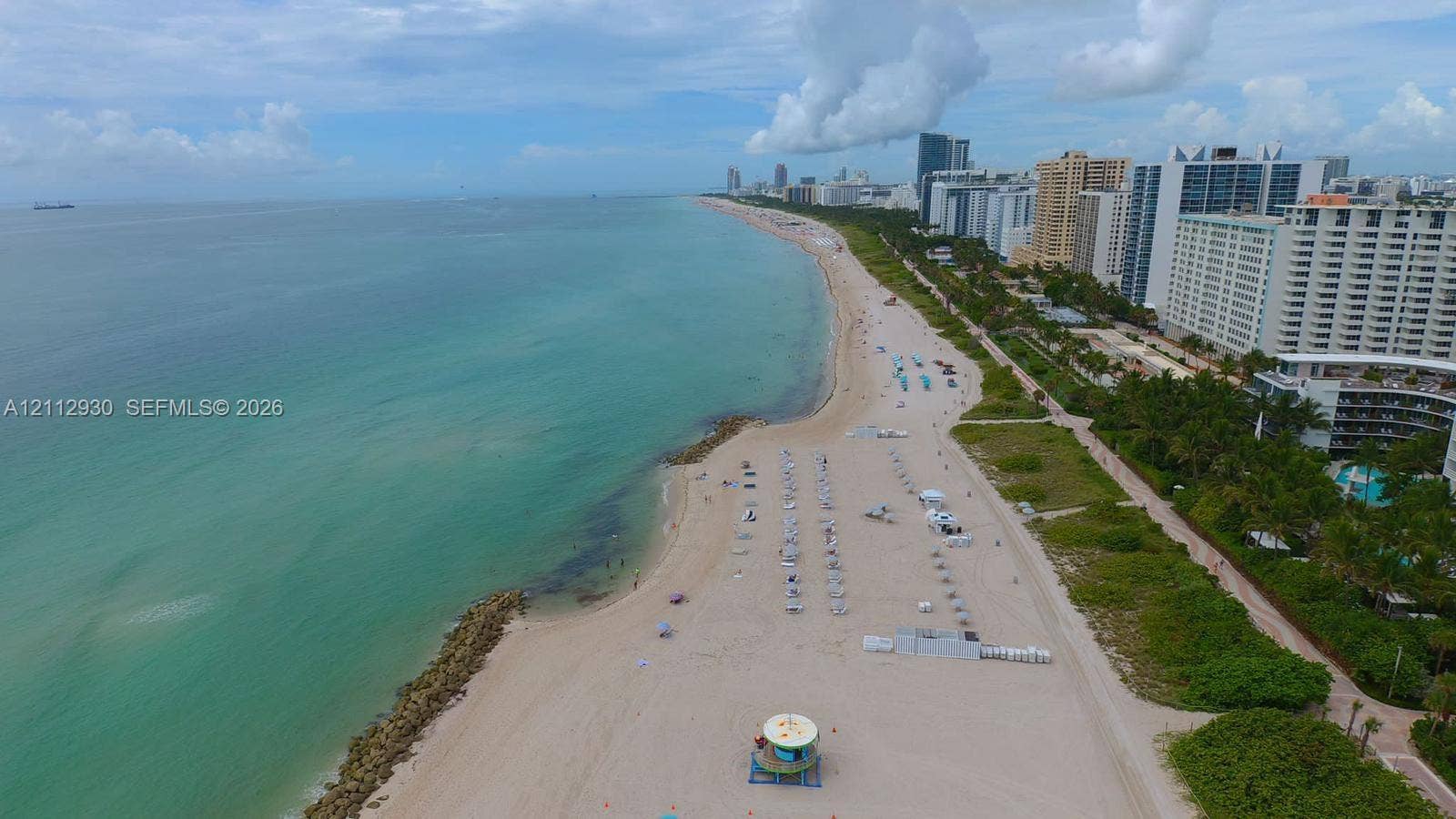 3030 Collins Avenue, #1G, Miami Beach, FL 33140 Aerial perspective featuring expansive sandy shoreline, turquoise coastal waters, and rock jetty elements